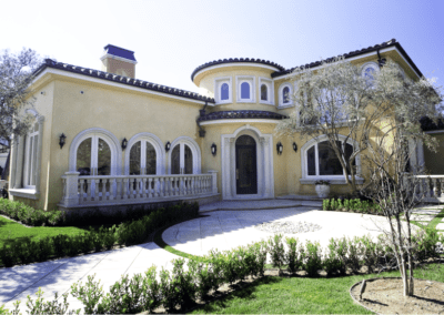 Elegant two-story mediterranean-style villa with balcony and landscaped garden.